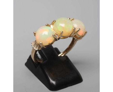 A THREE STONE OPAL RING, the round cabochon polished stones claw set to a plain 14ct gold shank, size P (Est. plus 24% premiu