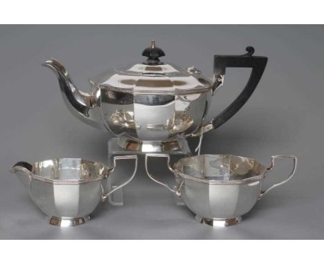 A SILVER THREE PIECE TEA SERVICE, maker Walker &amp; Hall, Sheffield 1924, of rounded panelled form with cast and applied her