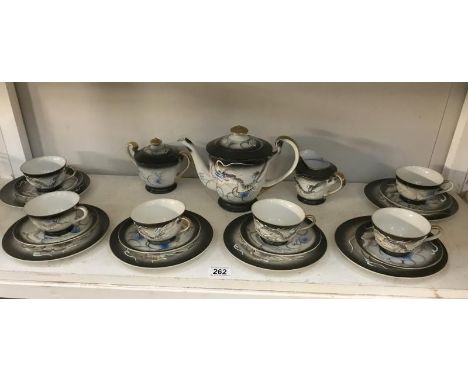 A Japanese dragon tea set with geisha face to bottom of cups