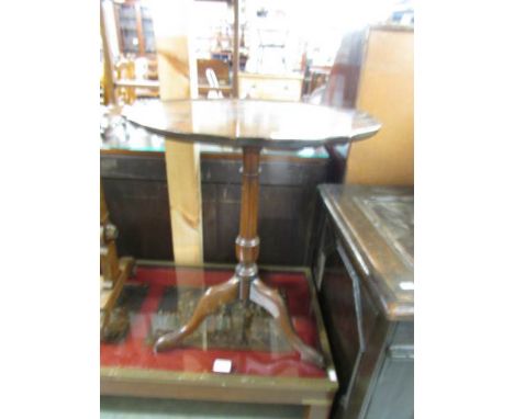 A mahogany tripod table with pie crust edge.