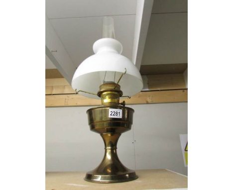 A brass oil lamp complete with shade and chimney.