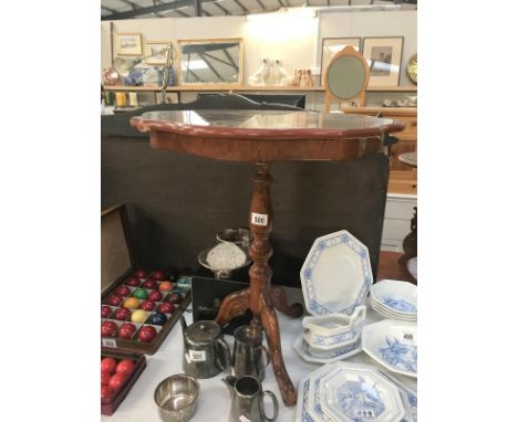 A dark wood stained tripod tea table with decorated top