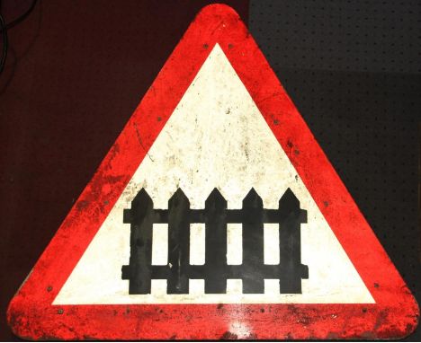 A triangular metal crossing gate road warning sign