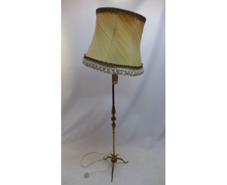 A brass standard lamp with cream coloured shade. H.140cm 