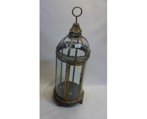 A gilt metal storm lantern on peg feet.