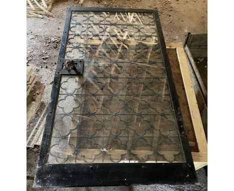 A heavy wrought and cast iron wine cellar security door and lock, with a plate glass inset panel, 186 x 105cm, together a rub