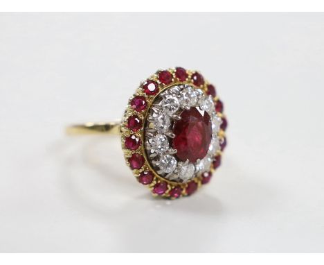 An 18ct, ruby and diamond cluster set oval cluster dress ring, size N/O, gross weight 6.3 grams.