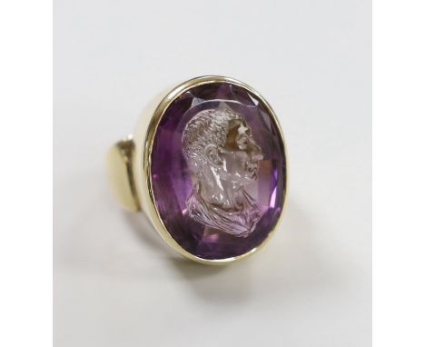 A modern 9ct yellow gold and amethyst intaglio set oval ring, carved with the head of a gentleman to sinister, size O, gross 