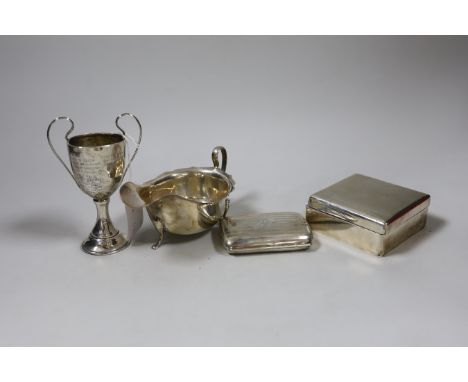 A George V silver sauceboat, a small silver cigarette box, a similar case and a small silver two handled trophy cup.