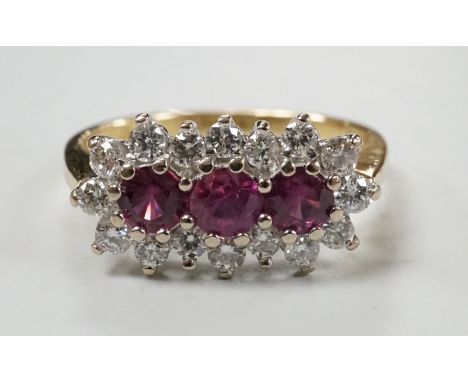 A modern 18ct gold, ruby and diamond set triple cluster ring, size L, gross weight 3.3 grams.