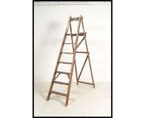 A vintage early 20th century wooden stepladder. The six step step ladder having a folding metamorphic action.