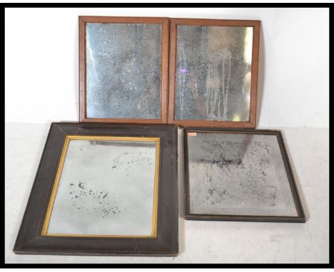 A group of four vintage early 20th century mirrors having wooden frames with inset foxed mirror panels.