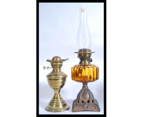2 vintage early 20th century oil lamps to include a gilt metal and amber glass reservoir example along with another brass exa