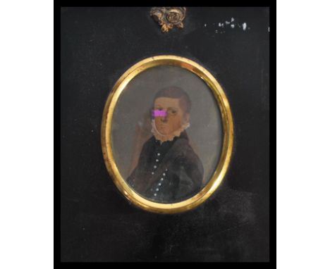 A 19th century portrait miniature painting of a boy in black suit set to a silhouette frame with gilt ormolu mounts. Frame me