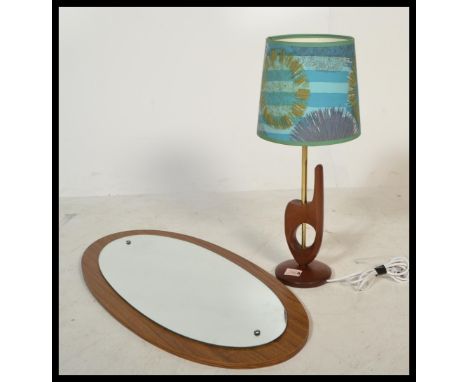 A vintage retro 20th century table lamp raised on circular base with central brass column along with a teak oval frameless mi