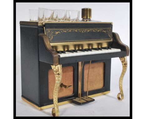 A vintage 20th century drinks compendium decanter and six glass set within a musical piano case.&nbsp;