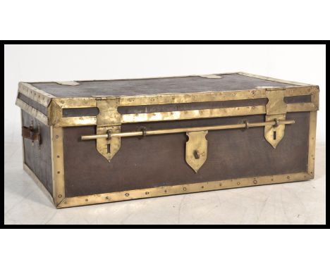 An antique large decorative leather and brass bounded trunk with side carry handles having sliding bar double locking mechani