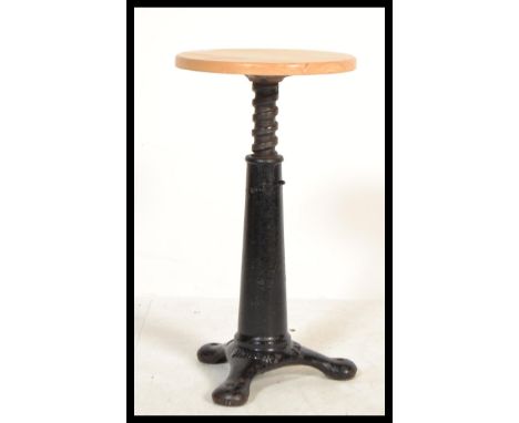 A vintage early 20th century Singer sewing machinist industrial stool raised on a quadruped cast iron base with swivel wooden