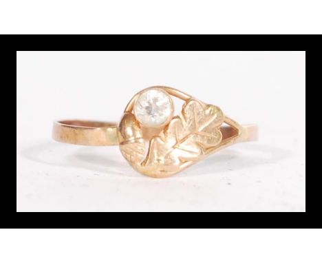 A 14ct gold ring having a leaf and acorn motif with white stone. Size R.5.