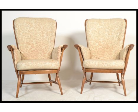 A pair of vintage / retro 20th century Ercol Windsor armchairs complete with the original cushions in a good paisley design. 