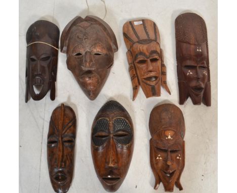 A group of vintage 20th century African tribal wooden masks some having inlaid decoration.