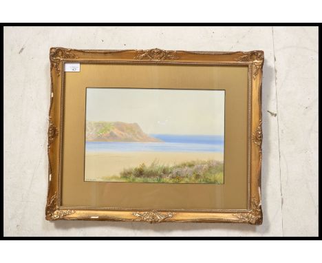 An early 20th century oil and colour painting on board of a seascape and clifftop scene being signed illegibly to the corner.