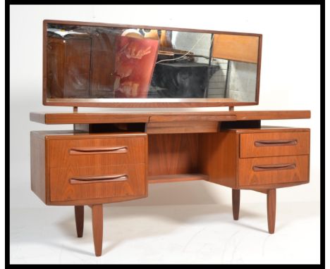 A vintage retro 1970's retro teak wood G-Plan Kelso dressing table having pedestals of drawers raised over tapered supports w