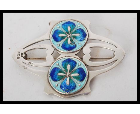 An early 20th century large silver hallmarked brooch in the manner of Archibald Knox for Liberty and Co having two blue guill