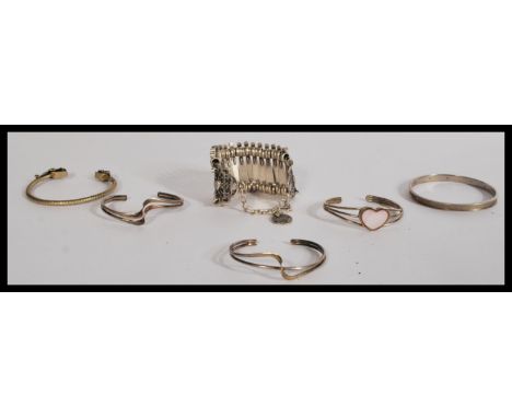 A group of vintage sterling silver bangles along with a white metal example and a silver white metal panel bracelet. Please s