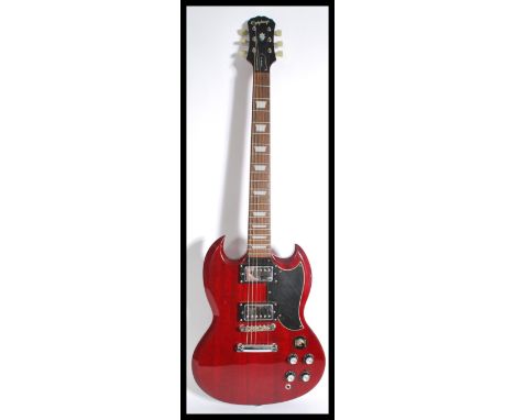 A vintage Gibson electric Epiphone six string guitar having a shaped red body with black scratch guard. Measures 102 cm high.