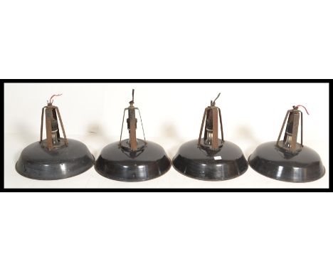 A set of four vintage 20th century retro industrial factory pendant lights of UFO form finished in a black enamel paint with 