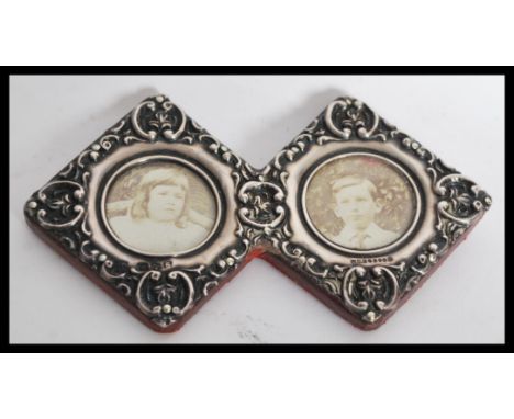 A silver hallmarked double diamond lozenge sweetheart photograph frame with rococo detailing in relief. Hallmarked for James 