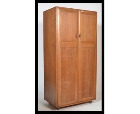 A stunning light beech and elm wood Ercol two door ' Windsor pattern ' wardrobe, fitted with twin full length doors. Measures