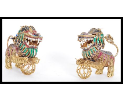 A pair of early 20th century Chinese cloisonne enamel articulated fu dogs temple lions having moving tails holding incense gl