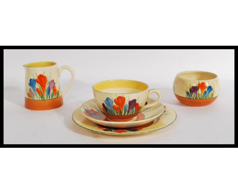 A vintage 20th century Clarice Cliff tea for one in the Crocus pattern consisting of a cup saucer and side plate trio , milk 