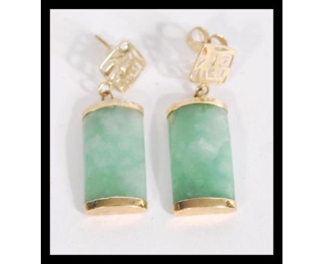 A pair of Chinese 9ct gold and jade earrings having a central jade panel with 9ct gold ends with character mark posts. Weighs