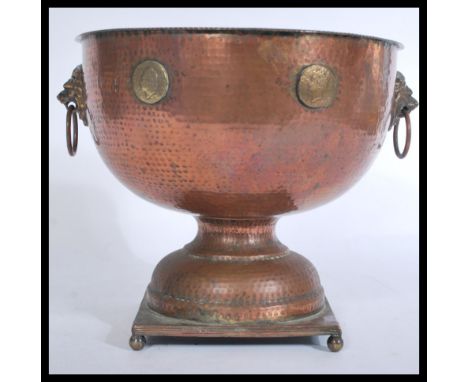 A 19th Century Victorian Arts and Crafts large copper hand worked pedestal rose bowl, twin lion mask drop handles to the side
