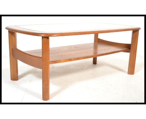 A vintage retro 20th century Danish influence teak coffee table raised on tapered supports having glass insert top and shelf 