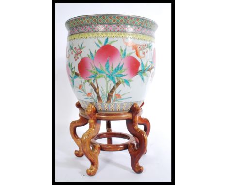 A 20th century large Chinese ceramic planter jardiniere, decorated with peaches and bats of cylindrical form raised on a shap