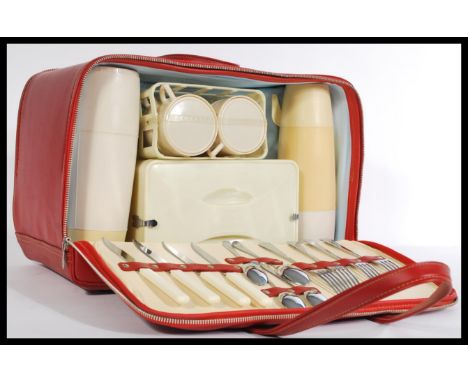 A vintage retro 20th Century Brexton picnic hamper / set, housed within a red vinyl case with two zip compartments with conte