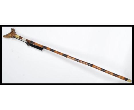 A vintage walking stick cane having a tapering tortoiseshell effect bamboo cane with the handle being a carved thrush bird.&n