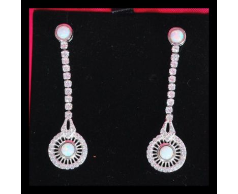 A pair of sterling silver opal and CZ drop earrings having opal post back tops with CZ strand and circular opal medallion to 