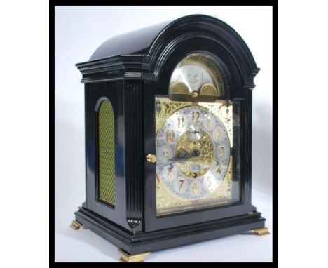 A Kieninger of Germany EBONISED mahogany cased musical bracket clock, in the 18th century style having AN arched brass dial w
