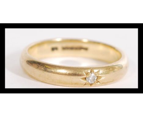 A hallmarked 9ct gold band ring having an inset diamond stone in a star settings. Size R weighs 4.2 grams.