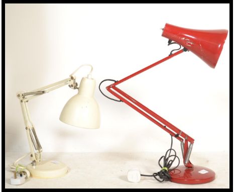 Two vintage retro 20th century anglepoise type desk lamps in red and cream colourways raised on circular bases with pendant s