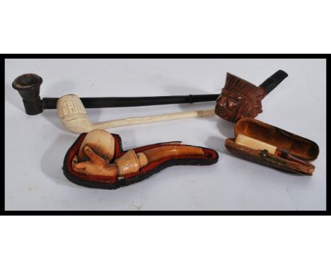 A good groups of vintage pipes to include a carved Native American Red Indian head pipe , hand and cup pipe in partial leathe