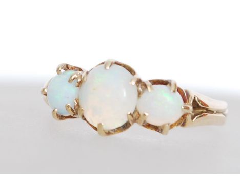 A hallmarked 9ct gold three stone opal ring set with a large central opal panel flanked by two opal panels. Weighs 2.2 grams 