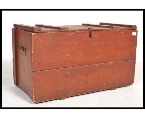 An early 20th century painted wooden trunk having cast iron drop handles. Hinged lid opening to reveal a spacious interior. P