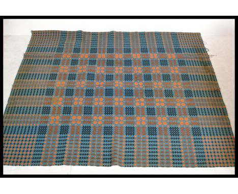 A vintage 20th Century traditional Welsh woollen carthen type fringed blanket with geometric decoration on a blue ground with