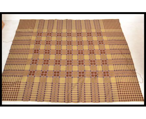 A vintage 20th Century traditional Welsh woollen carthen type fringed blanket with geometric decoration on a brown ground.&nb